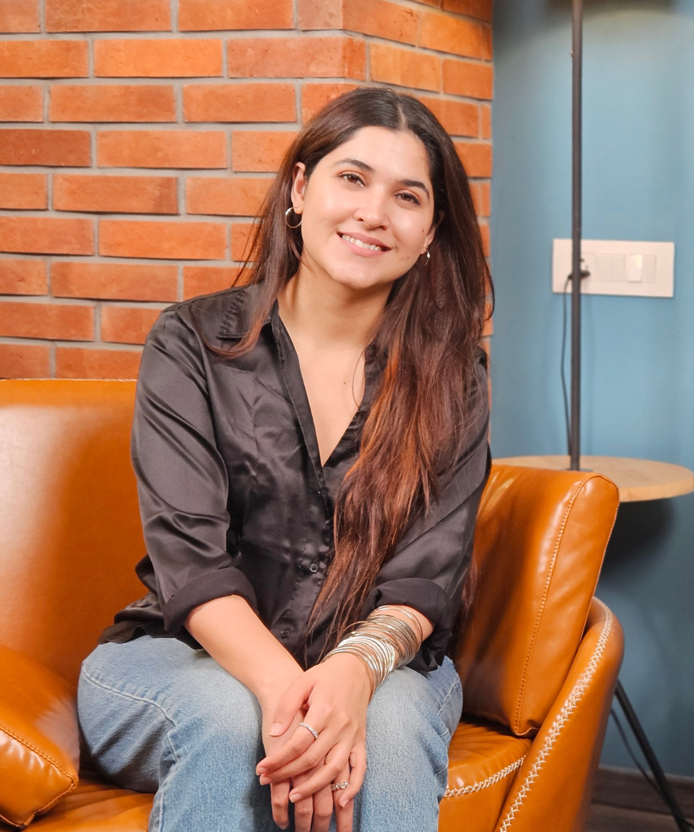 Jazz Sethi with a smiley face, seated on the guest chair of The Ripple Effect show, radiating positivity and inspiration.